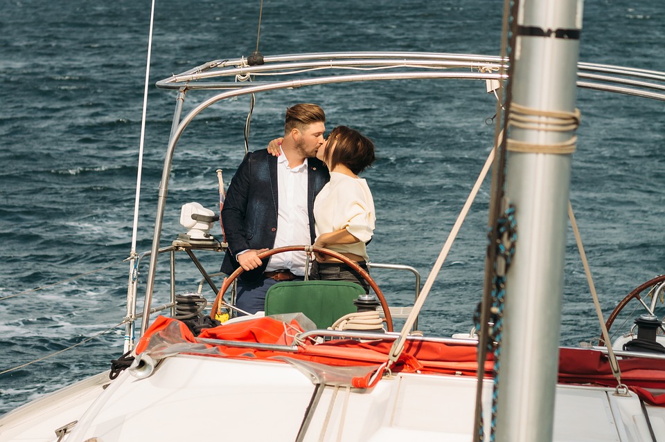 A couple on a yacht kissing.