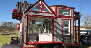 A wooden tiny house that is red and white.