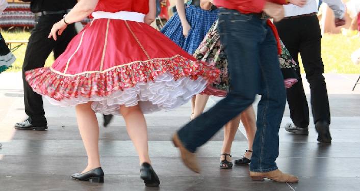 Men and women square dancing in festive outfits at a hoedown in Hastings, FL.