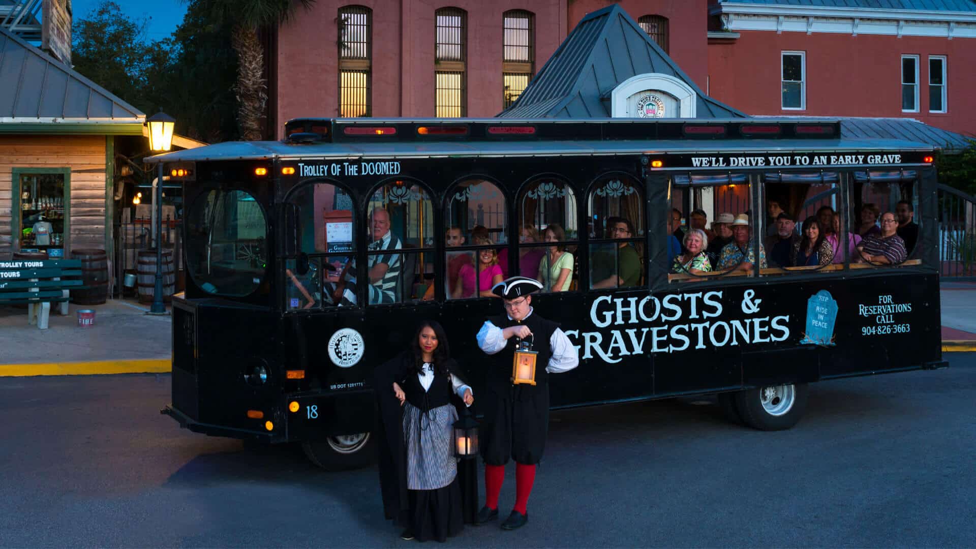 Ghosts & Gravestones black trolley full of people, with a man and a woman dressed in old colonial clothing.
