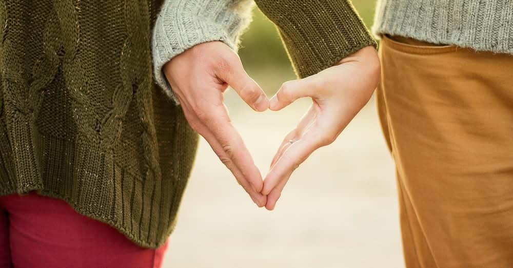 A couple making a heart with their hands